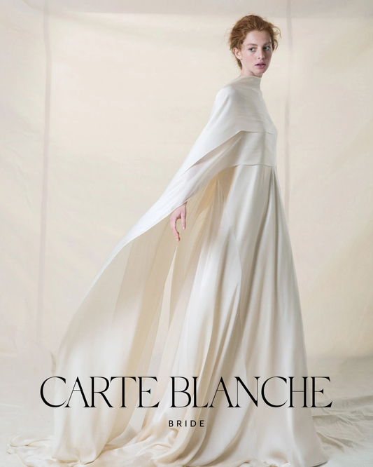 A bride wearing a 100% natural silk Cortana wedding gown, standing in a sun-drenched setting, showcasing the fluid movement and high-quality drape of luxury bridal fabric.