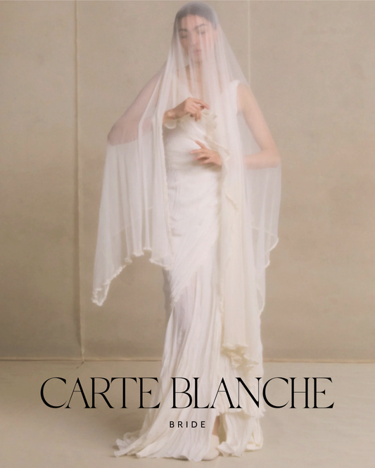 A long, ethereal Novia silk tulle wedding veil by Cortana trailing behind a bride, showcasing the light and movement of French-inspired bridal accessories.