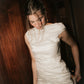 Close-up view of the wide boat neckline and ruched bodice on the Bella Set bridal gown.