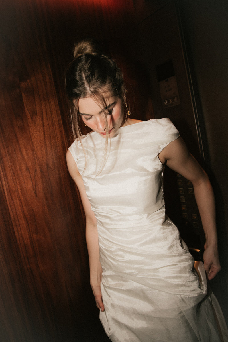 Close-up view of the wide boat neckline and ruched bodice on the Bella Set bridal gown.