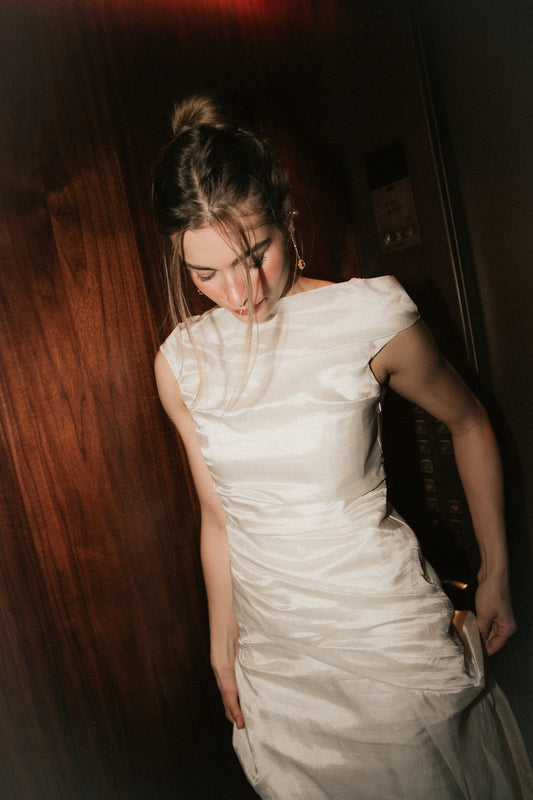 Close-up view of the wide boat neckline and ruched bodice on the Bella Set bridal gown.