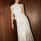 Full-length view of the modern silk Bella Set wedding dress by The Muse Collective leaning against wood paneling.
