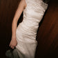 Close-up texture detail of the gathered silk drape and asymmetric waistline on the Bella Set top.