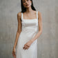 Close portrait view of the Unbridled Studio Clara wedding gown detailing the smooth silk fabric and tailored waist.