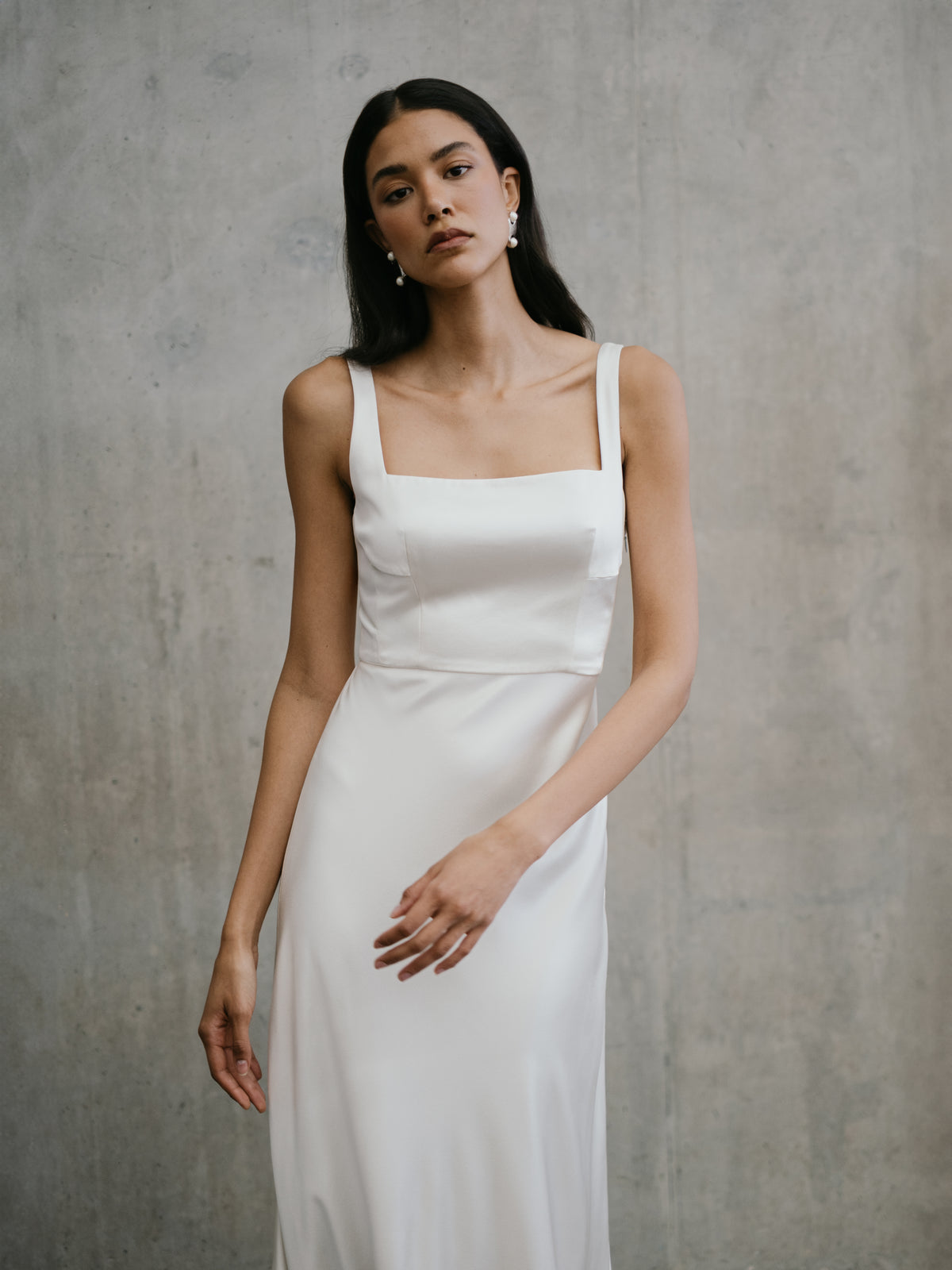 Close portrait view of the Unbridled Studio Clara wedding gown detailing the smooth silk fabric and tailored waist.