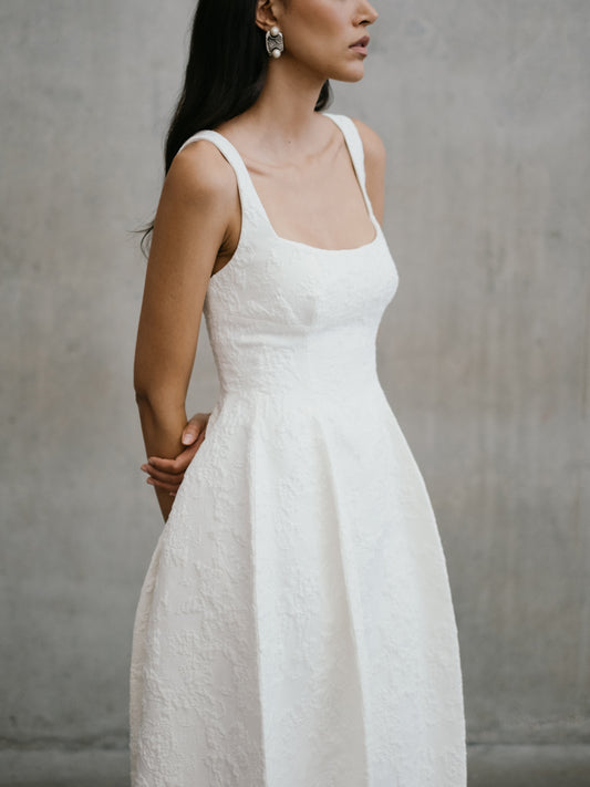 Side-angle close-up of the structured square-neck bodice and jacquard texture on the Thora bridal dress.