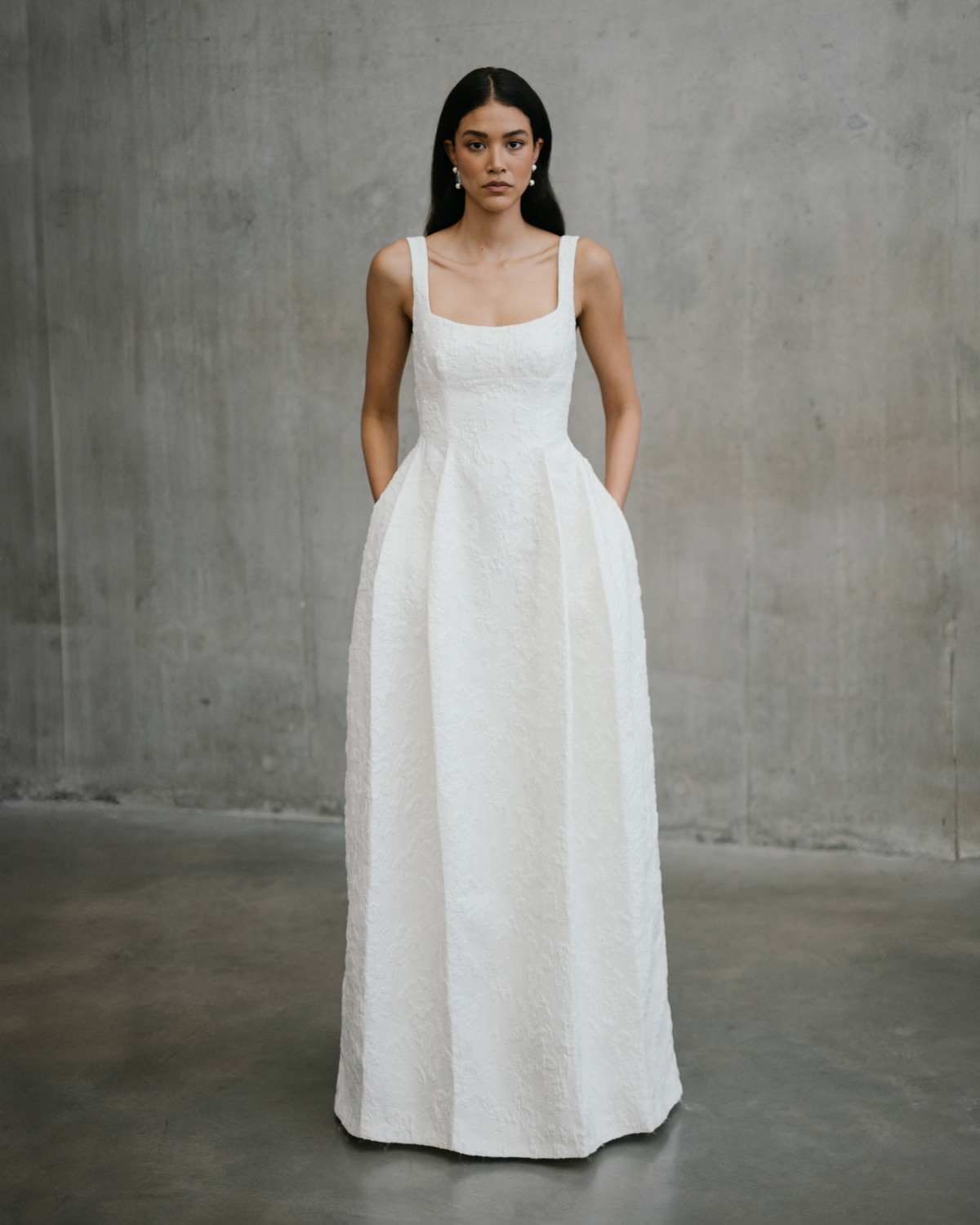 Full length front view of the Unbridled Studio Thora textured jacquard wedding gown with square neckline and hidden pockets at Carte Blanche Bride Australia.