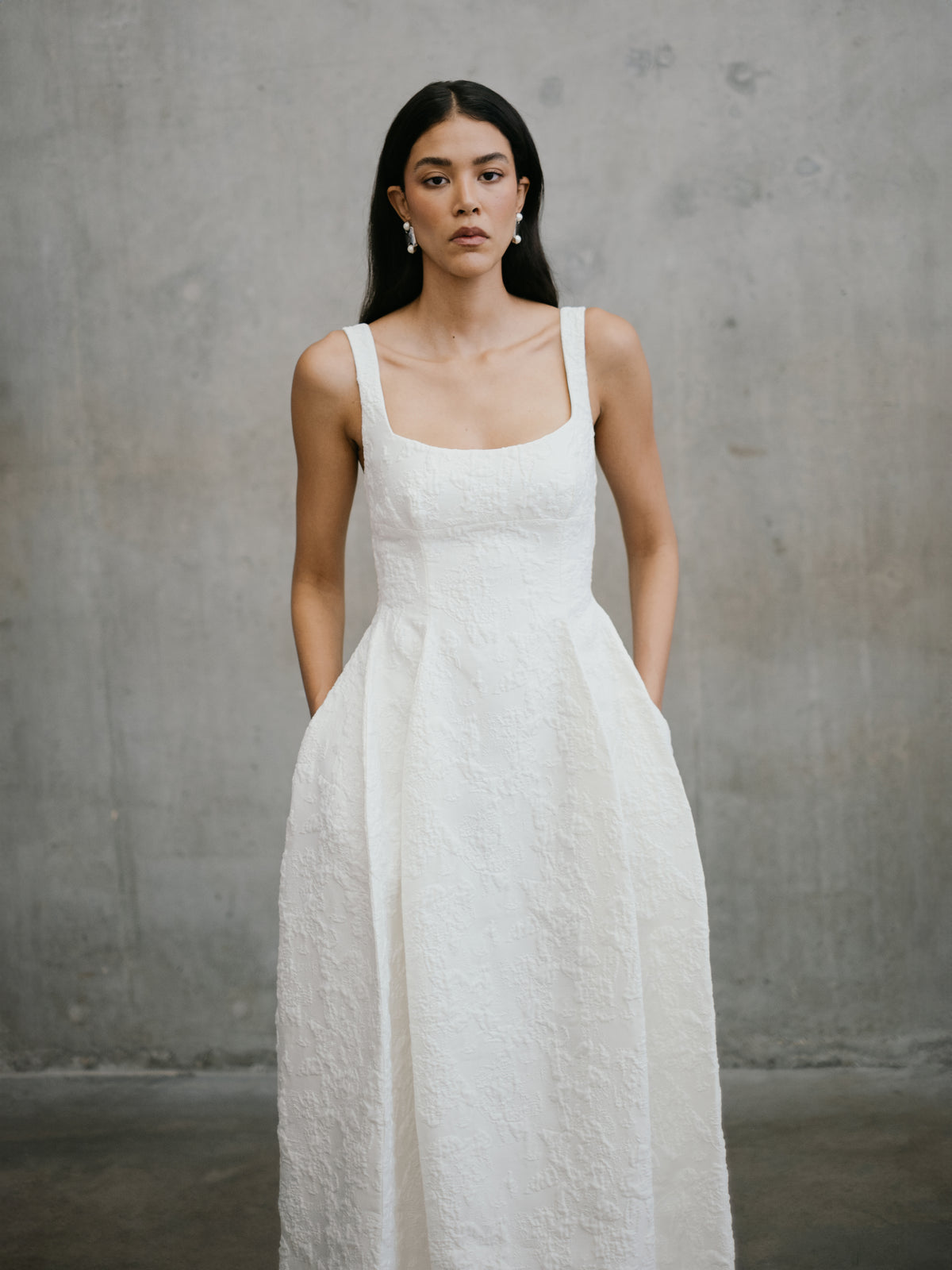 Medium front shot highlighting the square neckline and textured jacquard weave of the Thora wedding dress by Unbridled Studio.