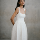 Three-quarter portrait of model wearing the Unbridled Studio Thora gown with wide shoulder straps and fitted waist.